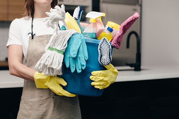 Woman carrying cleaning supplies